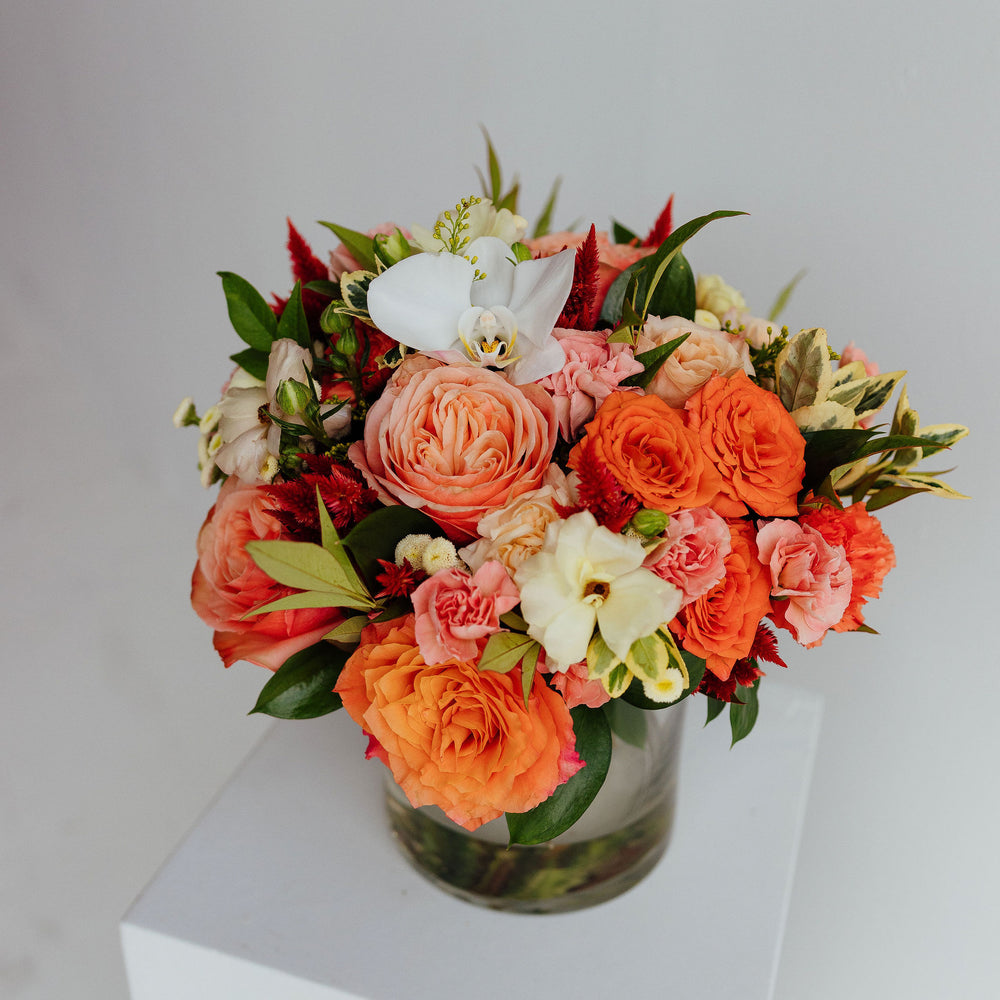 
                  
                    Fall-themed flower arrangement in a glass vase
                  
                