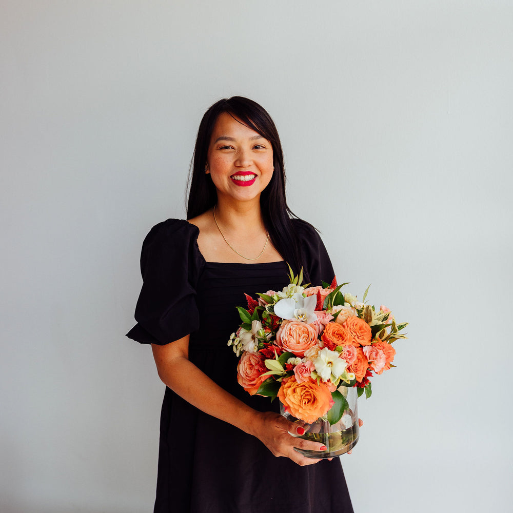 
                  
                    Fall-themed flower arrangement in a glass vase
                  
                